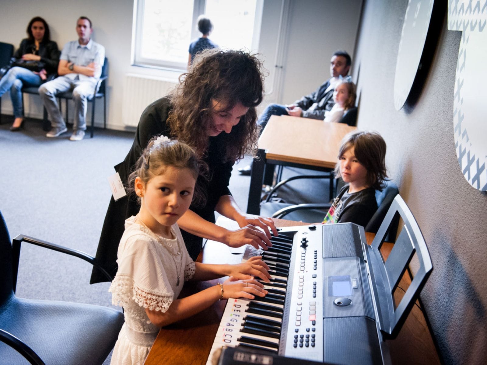 Foto: pianoles met docent en leerling
